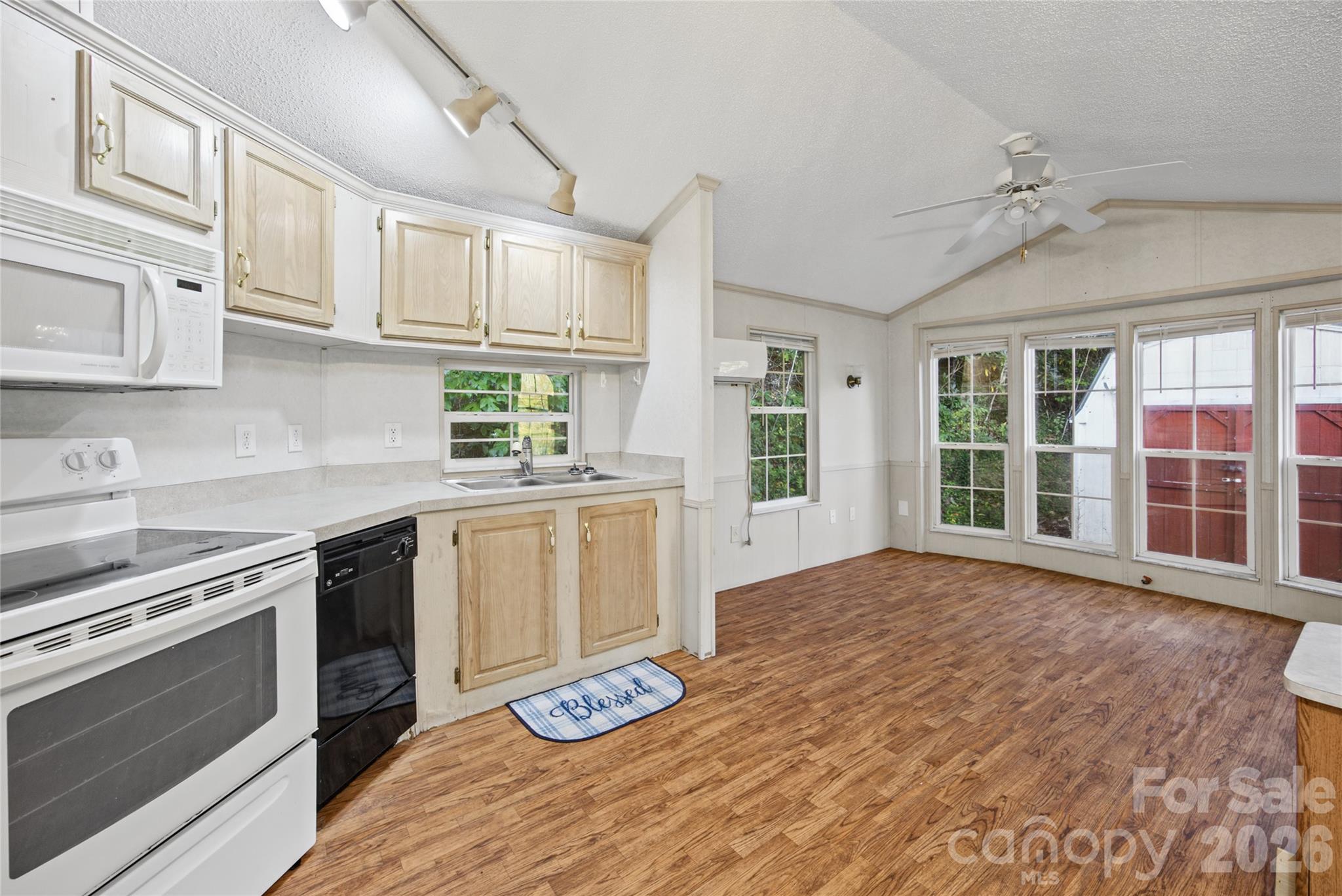 Kitchen includes generous cabinetry, electric range, microwave, and refrigerator. - 13858 Cruso Road, Canton