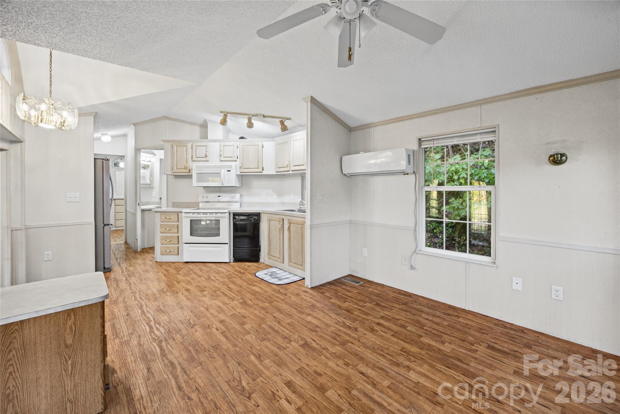 Open kitchen and living area with vaulted ceiling and natural light. - 13858 Cruso Road, Canton