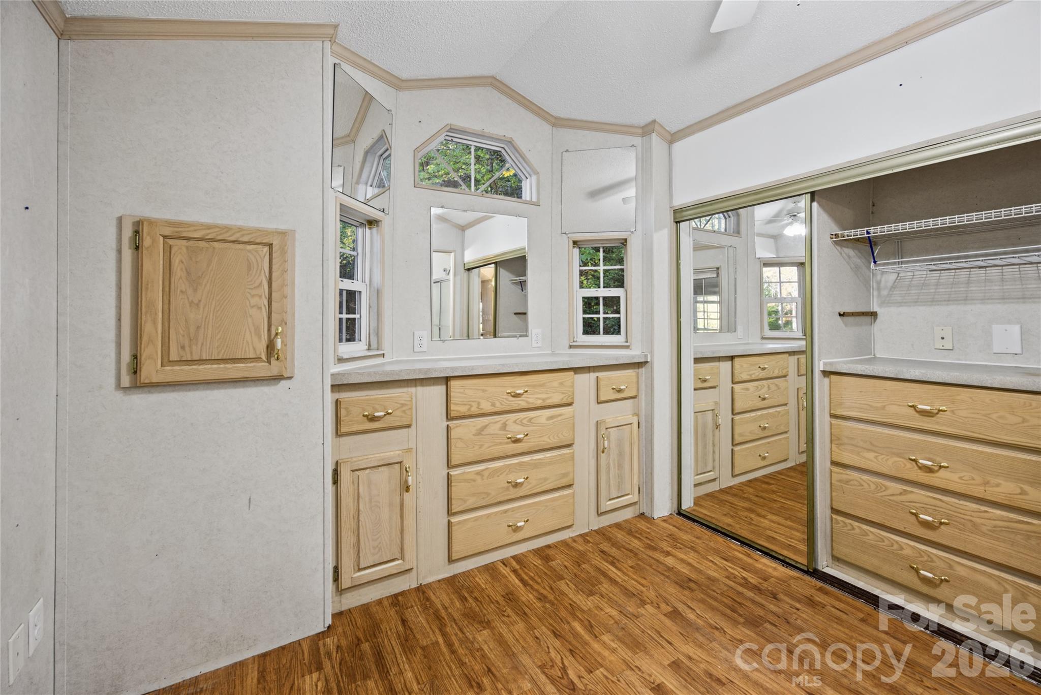 Bedroom features built-in drawers, generous cabinetry, and mirrored closet doors. - 13858 Cruso Road, Canton