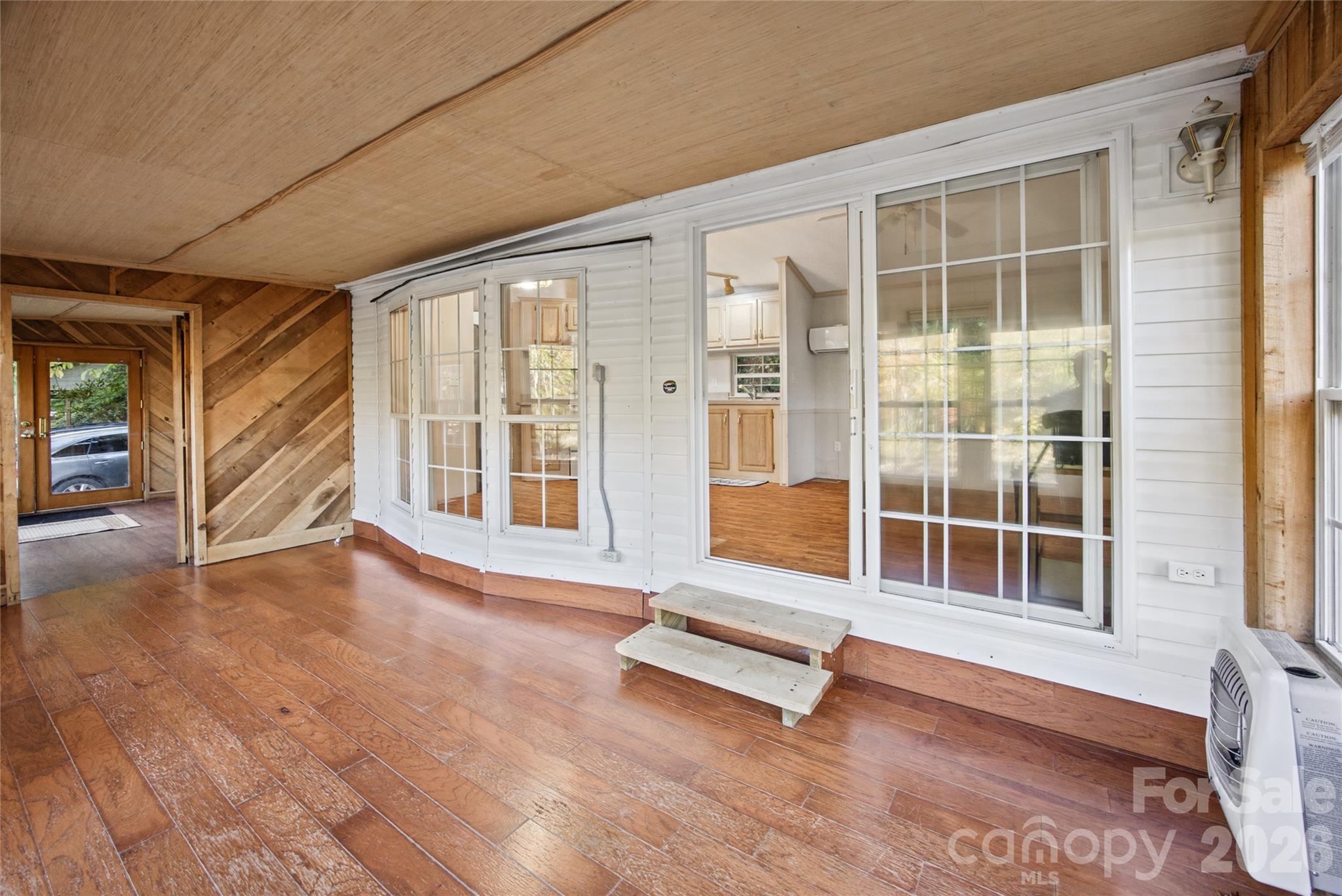 Interior view showing the connection between the living area and enclosed sunroom. - 13858 Cruso Road, Canton