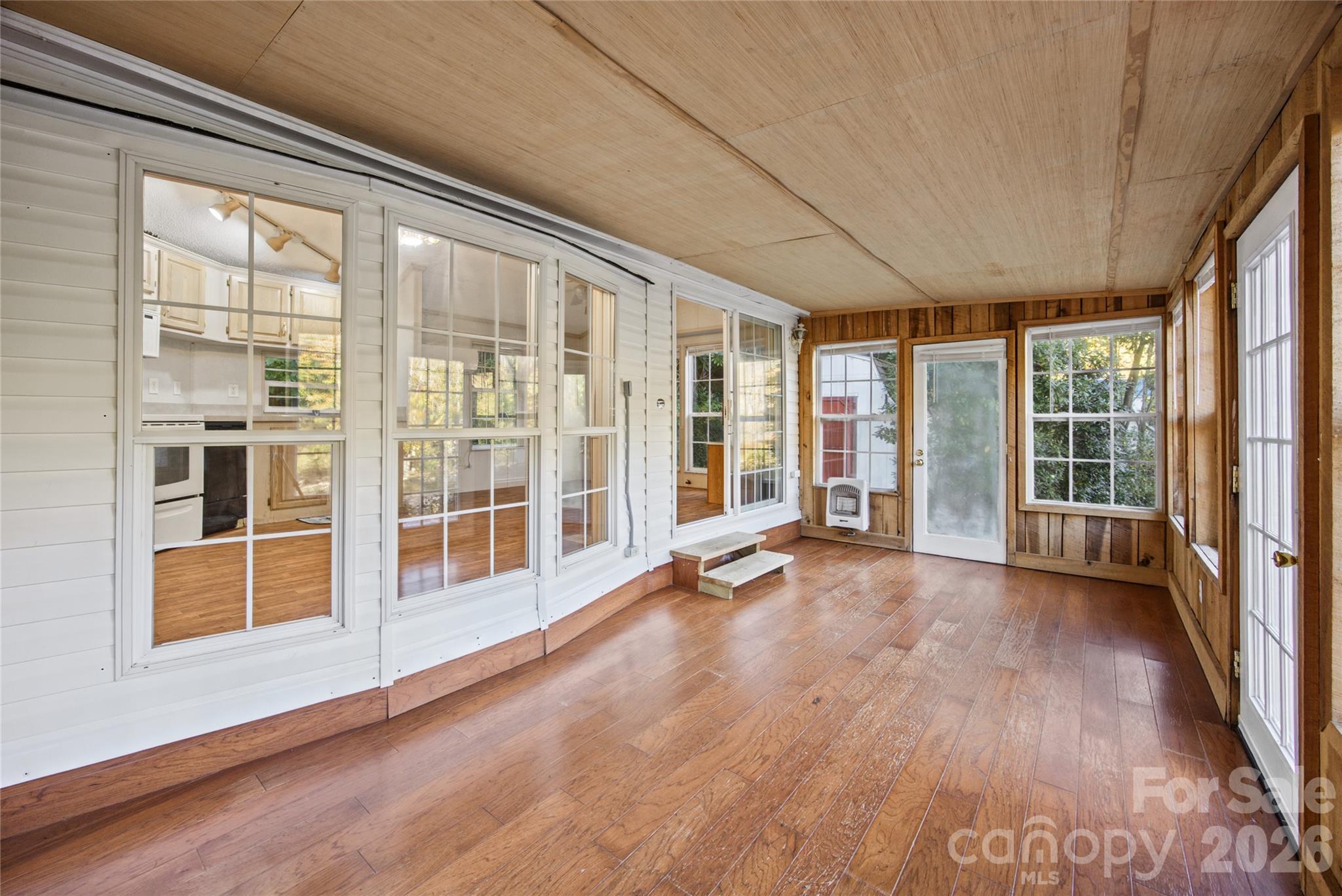Spacious enclosed sunroom with natural wood finishes and abundant windows - 13858 Cruso Road, Canton