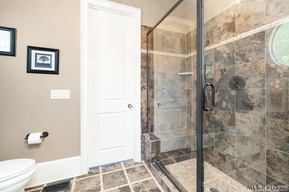 Sophisticated Custom-Tiled Walk-in Shower , Sleek frameless glass enclosure and dramatic, large-format stone tile. - 381 West Bend Dr., Gasburg VA 23857