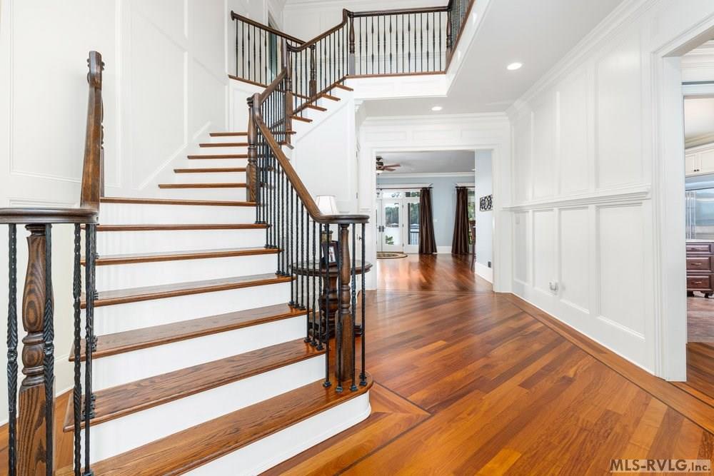 Grand Staircase, Beautiful wide-plank Brazilian hardwood floors paired with elegant wainscoting. - 381 West Bend Dr., Gasburg VA 23857