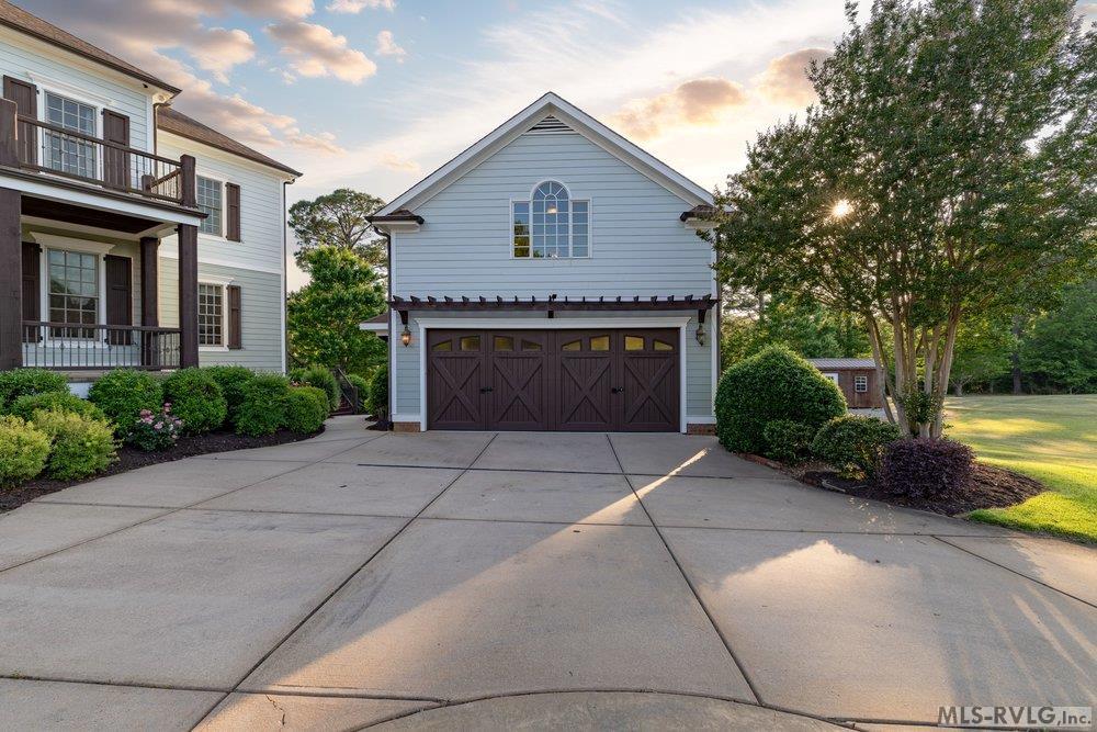 Classic Carriage House Charm, This detached garage captures the timeless charm of a vintage carriage house, offering more than just storage with its pool table, wet bar, and half bath upstairs. - 381 West Bend Dr., Gasburg VA 23857
