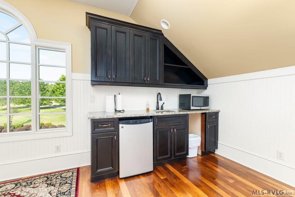 Sleek Wet Bar, Elevate your hosting game with espresso-toned cabinetry and premium countertops, perfectly designed for entertaining with a built-in fridge and wet bar. - 381 West Bend Dr., Gasburg VA 23857