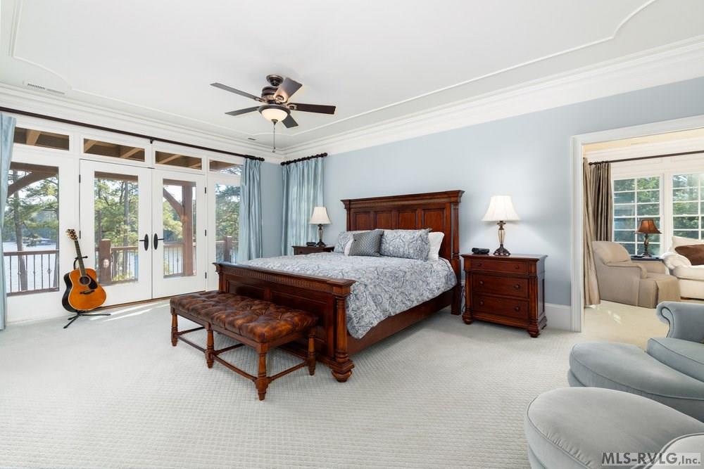 Primary Suite, A spacious traditional bedroom that emphasizes comfort and timeless style, offering a beautiful view of Lake Gaston. - 381 West Bend Dr., Gasburg VA 23857